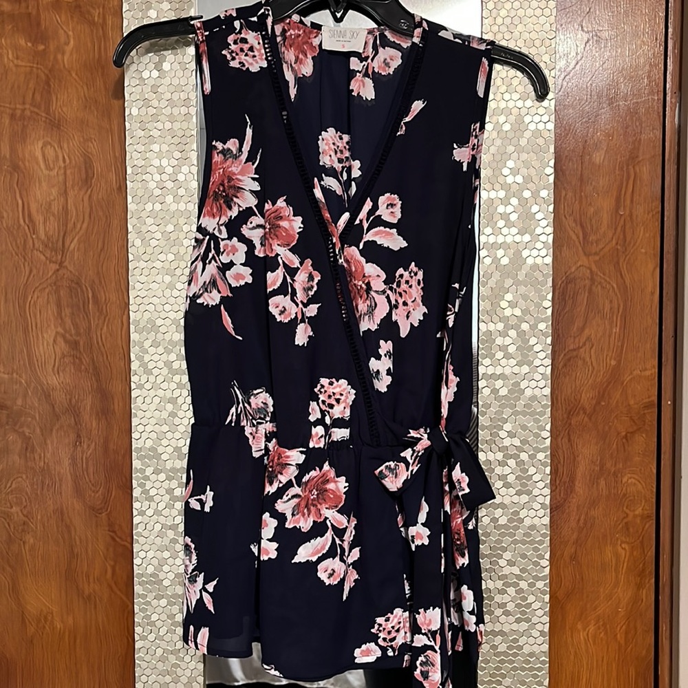 Sienna Sky sleeveless peplum wrap top.